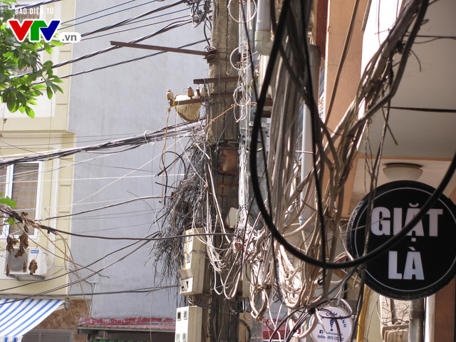 Những cây cột điện, mạng dây điện có nguy cơ cháy nổ cao trên đường phố Hà Nội - Ảnh 4.