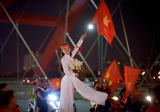 Thú vị hình ảnh thiếu nữ mặc áo dài vẫy cờ cổ vũ ĐT Việt Nam trên cầu Bình Lợi - Ảnh 2. Thú vị hình ảnh thiếu nữ mặc áo dài vẫy cờ cổ vũ ĐT Việt Nam trên cầu Bình Lợi - Ảnh 2.