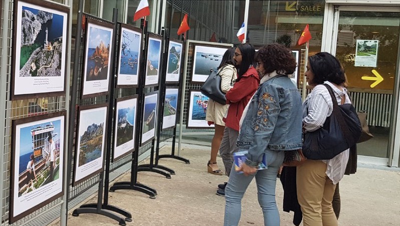 French visitors admiring photos on display at an exhibition highlighting Vietnam’s sea-based tourism. (Photo: VOV)