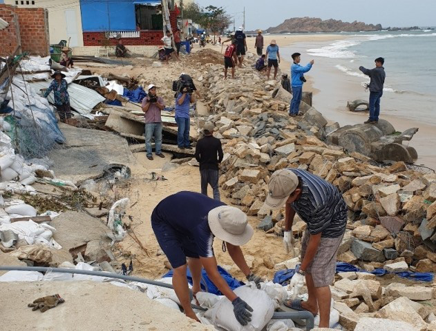 Locals in Nhon Hai commune, Quy Nhon city strengthen a sea embankment section to brace against Storm Nakri. (Photo: NDO/Cat Hung) 
