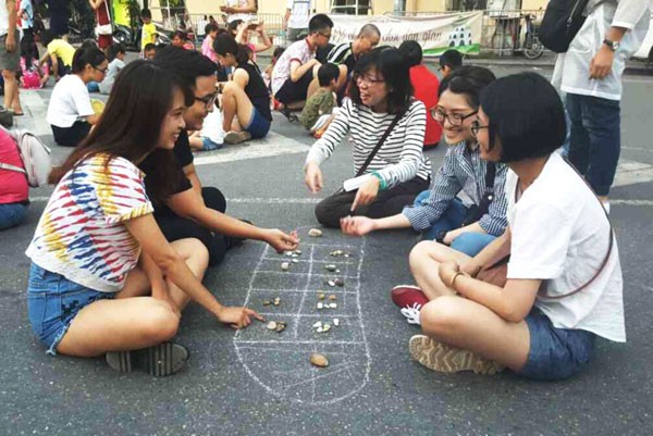 Schoolchildren playing o an quan (mandarin square capturing) at the first-ever Vietnam Olympic Folk Games held in September 2018 on Trinh Cong Son pedestrian street