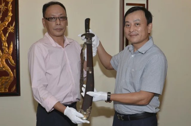 Vuong Quynh Xuan (L) presents the steel alloy sword to the Ho Chi Minh Museum. (Photo: Ho Chi Minh Museum) 