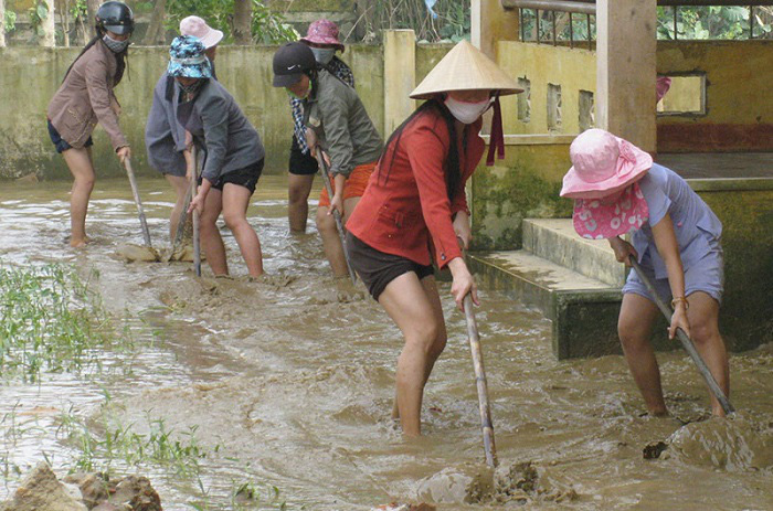 
Teachers in the Quang Ninh floodplain in Quang Binh Province clearing the mud at a local school to welcome back students after the flooding recedes. (Photo: NDO/Huong Giang) 
