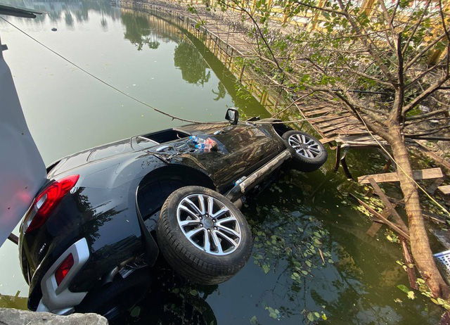 Ô tô 7 chỗ mất lái lao xuống hồ ở Hà Nội, 4 người thoát chết - Ảnh 1. Ô tô 7 chỗ mất lái lao xuống hồ ở Hà Nội, 4 người thoát chết - Ảnh 1.