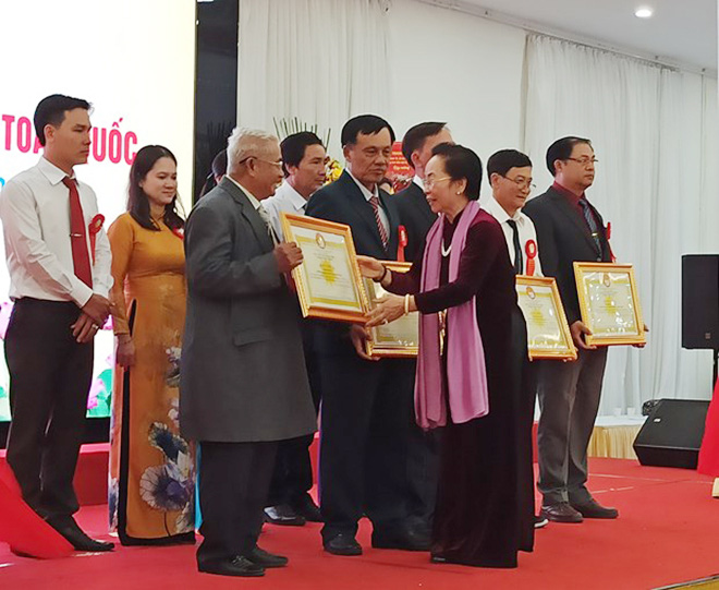 
Former Vice President Nguyen Thi Doan, President of the Vietnam Association for Promoting Education, presents certificates of merits to representatives of exemplary learning models. (Photo: qdnd.vn)
