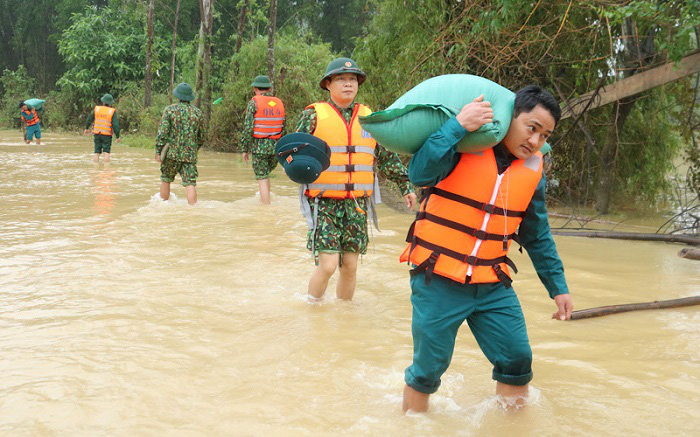 
Military Region 4 soldiers carrying rice and instant noodles to locals in separated floodplain areas in Thanh Chuong District, Nghe An Province. (Photo: NDO)
