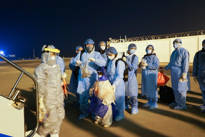 
Thirty Vietnamese citizens in Wuhan are in line, wearing protective clothing and equipment, waiting to return home. (Photo: Vietnam Airlines)
