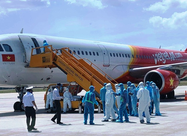 Quarantine staff disinfecting a flight at Da Nang International Airport. (Photo: NDO/Anh Dao) 
