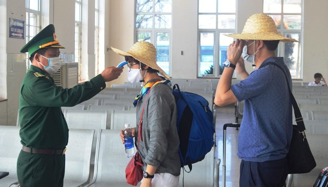 Passengers’ body temperature being checked before getting off a speedboat to Ly Son Island. (Photo: NDO/Hien Cu) 