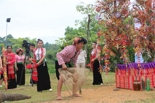 A shaman simulates the act of catching shrimp using a bamboo trap (Photo: dantocmiennui.vn)