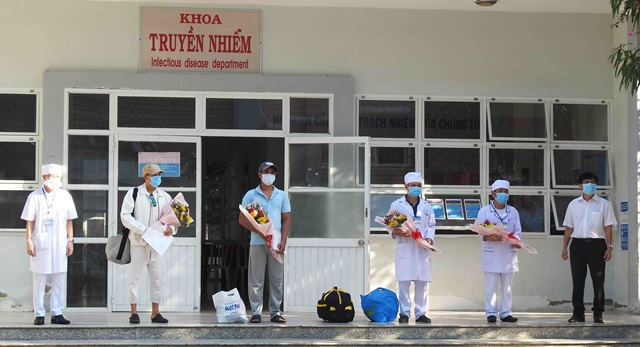 Leaders from Ninh Thuan Provincial Department of Health and Ninh Thuan Province General Hospital present flowers to congratulate two patients No. 61 and 67 and the hospital’s doctors during the duo’s release on April, 1, 2020. (Photo: NDO/Nguyen Trung)