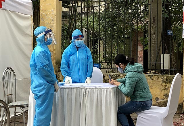 A local declares her health information before being tested at a field test station in Dong Da District, Hanoi, March 31, 2020. (Photo: NDO/Viet Anh) 