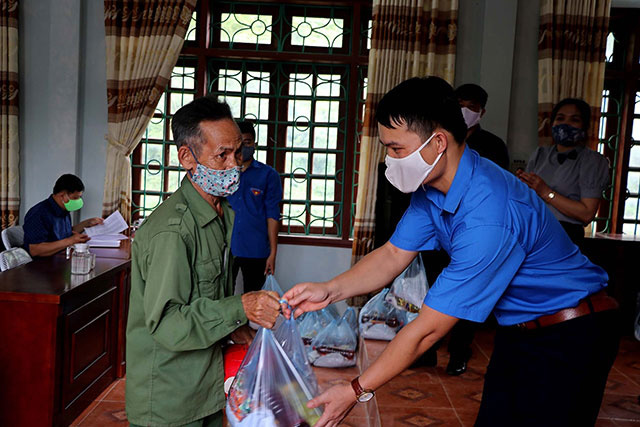 
A disadvantaged local receives free gifts from the “Happy trip programme run jointly by Apec Group and Hoa Binh Provincial Youth Union units, Hoa Binh, May 5, 2020. (Photo: NDO/Tran Hao) 
