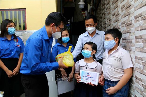 
Children who lost a parent to COVID-19 in HCM Citys District 4 receive tablets to study online from donors. (Photo: VNA)
