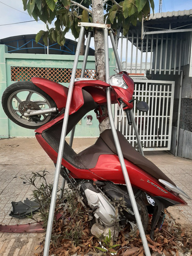 Xe m&aacute;y lao v&agrave;o gốc c&acirc;y, đứng nghi&ecirc;m trong r&agrave;o sắt - Ảnh 1.