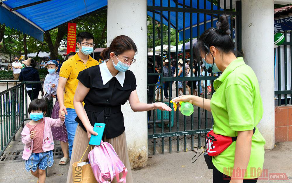 
Visitors disinfect their hands before entering Thu Le Park. (Photo: NDO/Duy Linh) 
