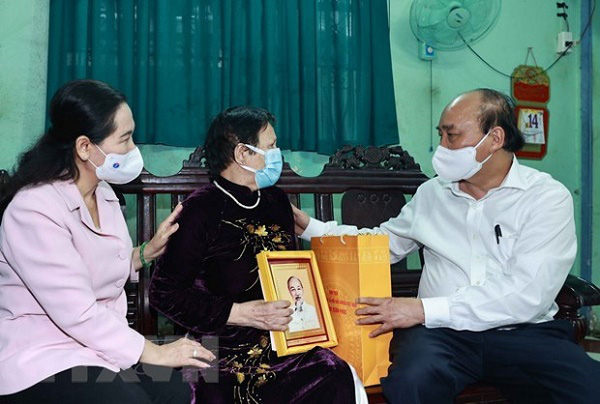 
State President Nguyen Xuan Phuc presents gift to Heroic Mother Nguyen Thi Xay in Hoc Mon district (Photo: VNA)
