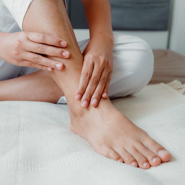 low-section-of-woman-with-ankle-pain-sitting-on-bed-royalty-free-image-1590090733