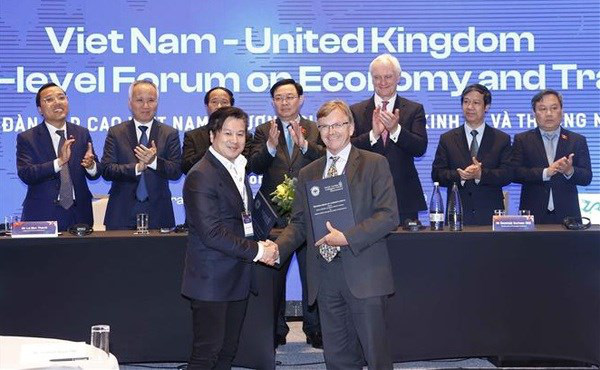 
NA Chairman Vuong Dinh Hue witnesses the exchange of cooperation agreements between businesses and localities of Vietnam and the UK (Photo: VNA)
