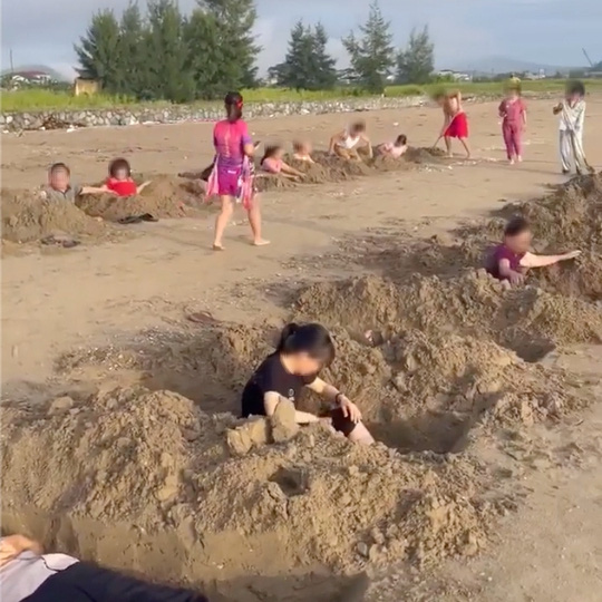 X&ocirc;n xao clip nh&oacute;m du kh&aacute;ch đ&agrave;o h&agrave;ng chục hố s&acirc;u như huyệt mộ rồi nằm xuống để... tắm c&aacute;t - Ảnh 2.