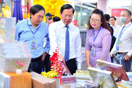 
Chairman of the HCMC People’s Committee Phan Van Mai (C) visits a display booth in Book Street Festival. (Photo: SGGP)
