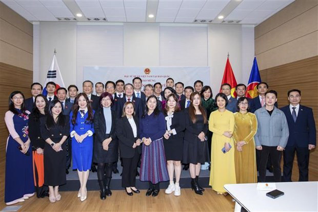 
The NA delegation, staff of the Vietnamese Embassy, and representatives of the Vietnamese community pose for a photo at the meeting on March 19. (Photo: VNA)
