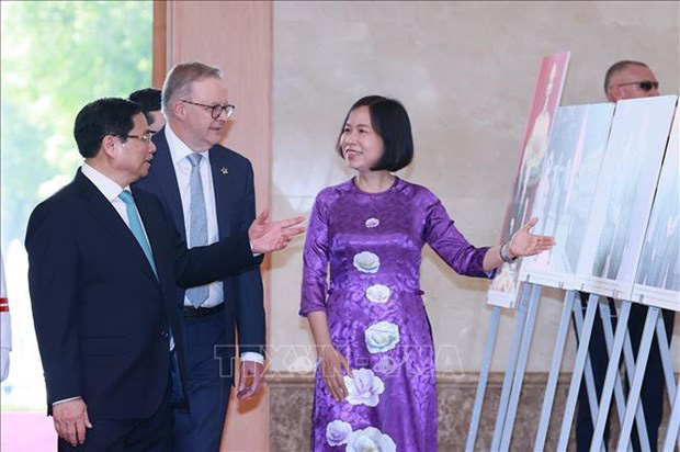 
General Director of the Vietnam News Agency Vu Viet Trang introduces the two PMs on the photos on display at the June 4 exhibition. (Photo: VNA)
