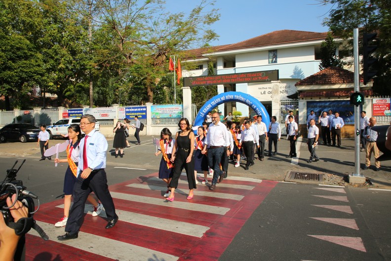 Delegates and students cross the street.
