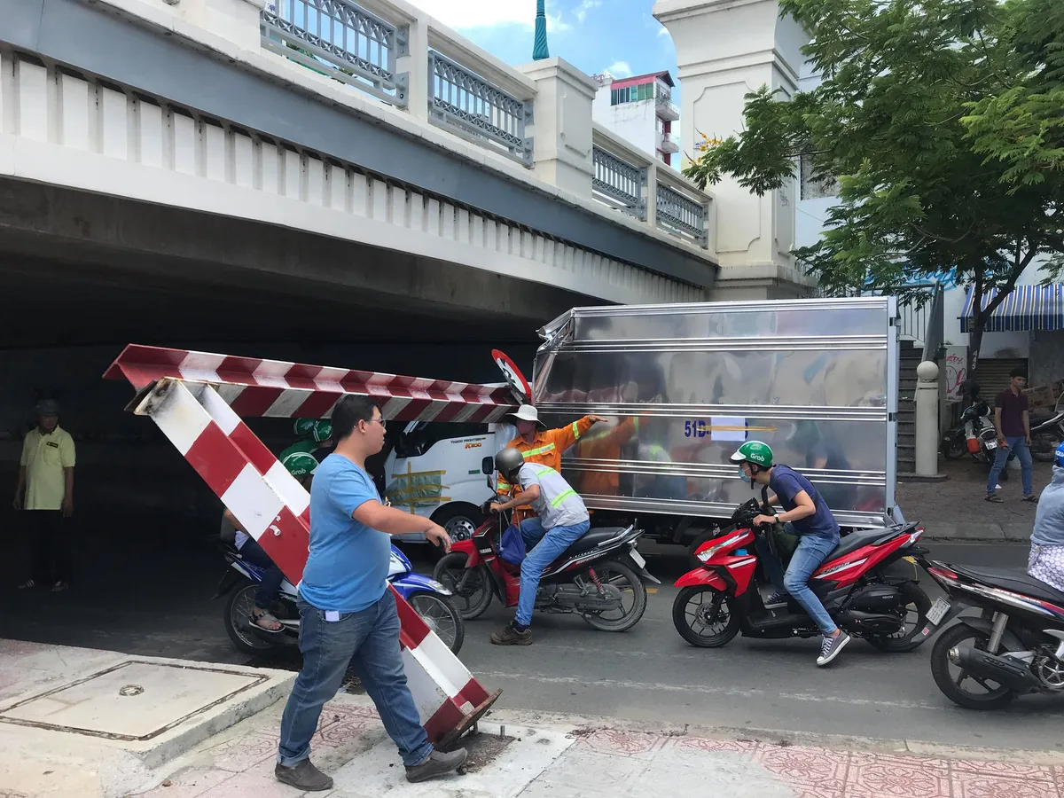 TP.HCM: Xe tải kéo ngã thanh giới hạn chiều cao dưới gầm cầu Bông - Ảnh 1.