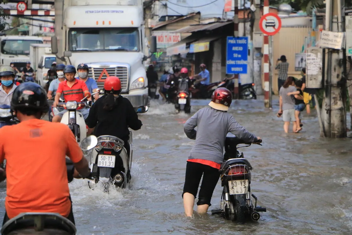 Triều cường đạt đỉnh, người dân TP.HCM bì bõm lội sông - Ảnh 2.