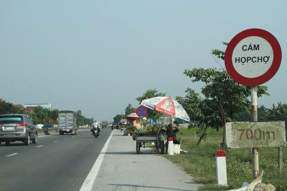 Mất an toàn giao thông từ tình trạng họp chợ ven đường - Ảnh 1.