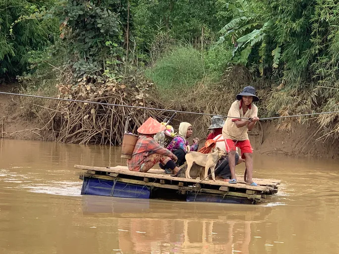 Không có cầu, người dân liều mình kéo bè qua sông - Ảnh 1.