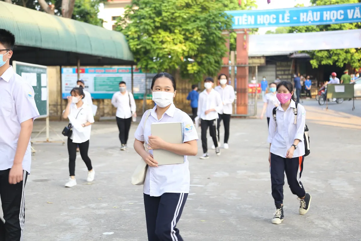 [Ảnh] Thí sinh đeo khẩu trang làm bài thi, phụ huynh hồi hộp chờ con vượt vũ môn - Ảnh 1.