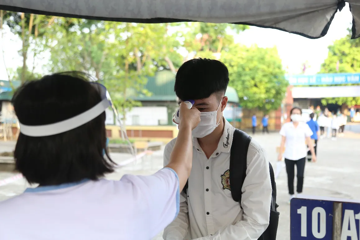 [Ảnh] Thí sinh đeo khẩu trang làm bài thi, phụ huynh hồi hộp chờ con vượt vũ môn - Ảnh 5.