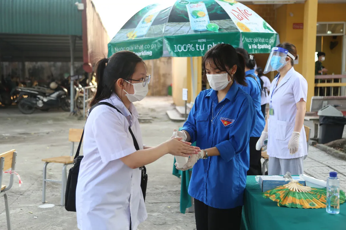 [Ảnh] Thí sinh đeo khẩu trang làm bài thi, phụ huynh hồi hộp chờ con vượt vũ môn - Ảnh 6.