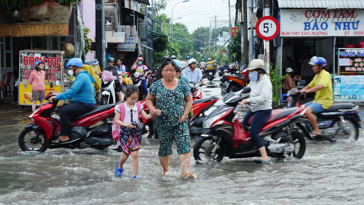 Triều cường vượt báo động 3, người dân bì bõm lội nước ngày đầu tuần - Ảnh 7.