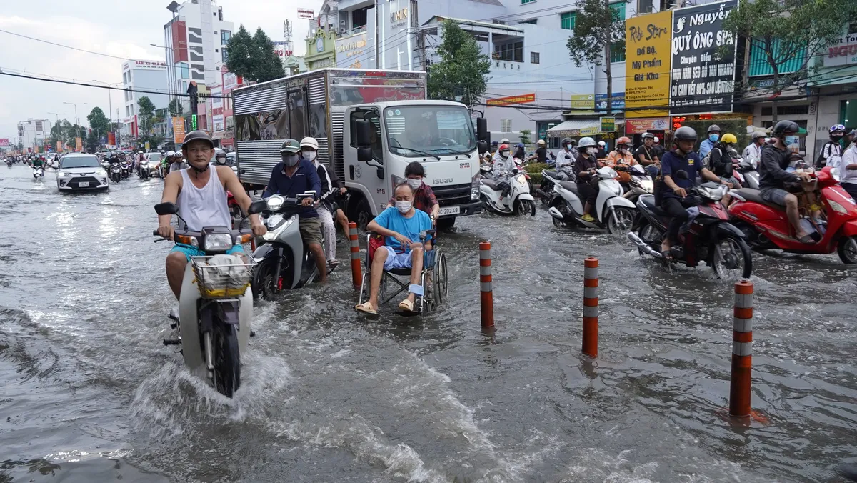 Triều cường tràn vào bệnh viện, người dân bì bõm đi làm ngày đầu tuần ở Cần Thơ - Ảnh 1.