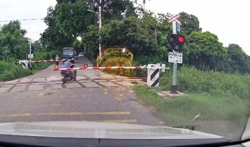 Bất chấp nguy hiểm, cố t&igrave;nh vượt thanh chắn đường sắt - Ảnh 3.