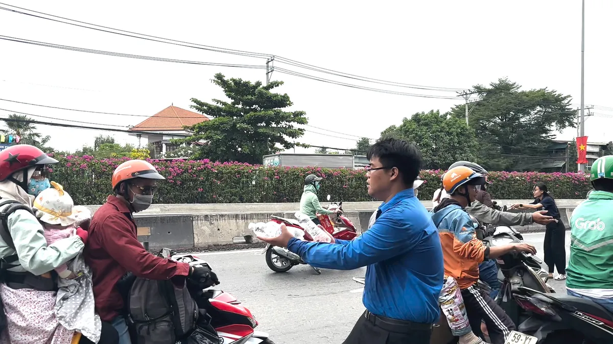 Cảnh sát giao thông phát nước, khăn lạnh miễn phí hỗ trợ người dân về quê đón Tết - Ảnh 3.