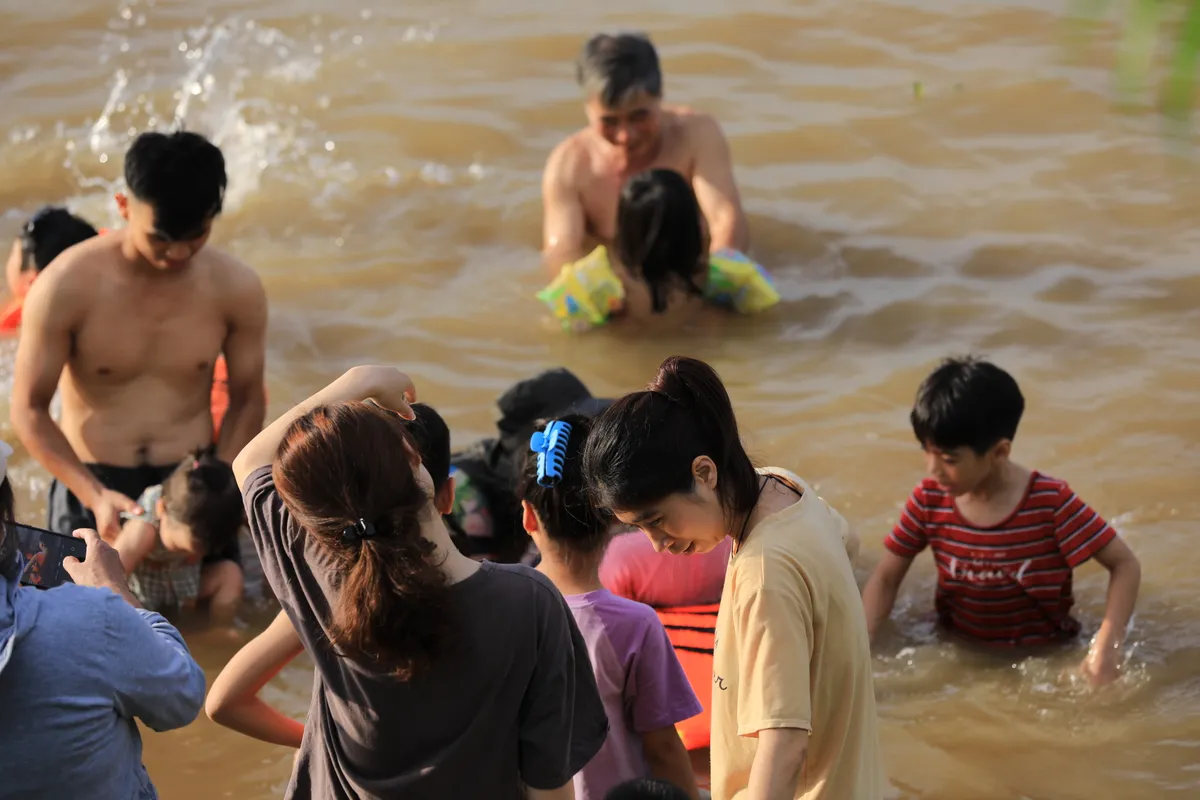 Người d&acirc;n đổ ra giải nhiệt ở c&aacute;c b&atilde;i tắm tự ph&aacute;t ven s&ocirc;ng Hồng - Ảnh 1.