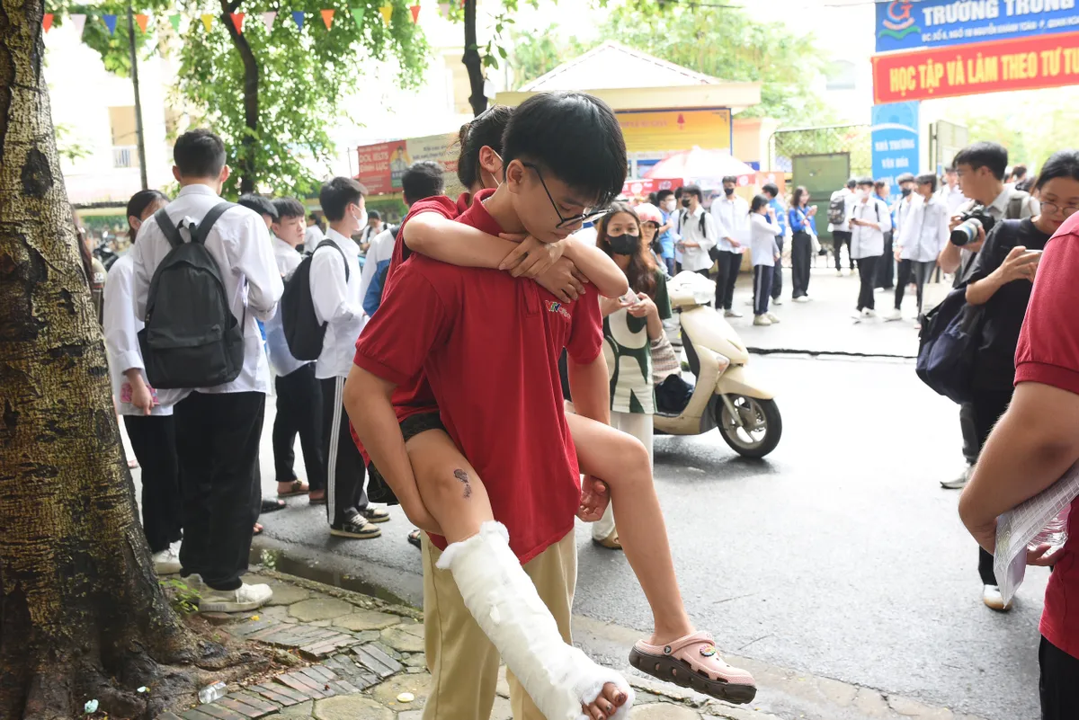 Cõng bạn và những hình ảnh ấn tượng trong buổi thi môn Ngữ văn sáng nay tại Hà Nội - Ảnh 1.