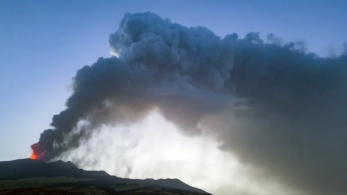 Núi lửa Etna ở Italy hoạt động mạnh trở lại, phun dung nham nóng đỏ và tro bụi khắp bầu trời - Ảnh 2.