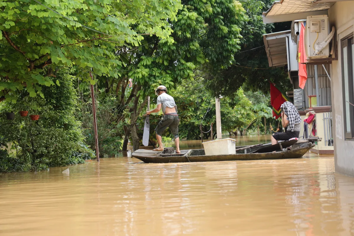 Hà Nội: Người dân thôn Bùi Xá di chuyển bằng thuyền do ngập - Ảnh 7.