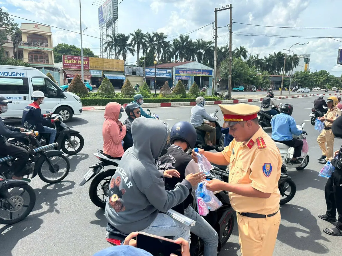 CSGT TP Hồ Chí Minh phát nước suối, khăn lạnh tiếp súc cho người dân đi đường - Ảnh 1.