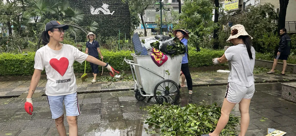 Người dân Hà Nội dọn dẹp đường phố sau cơn bão - Ảnh 3.