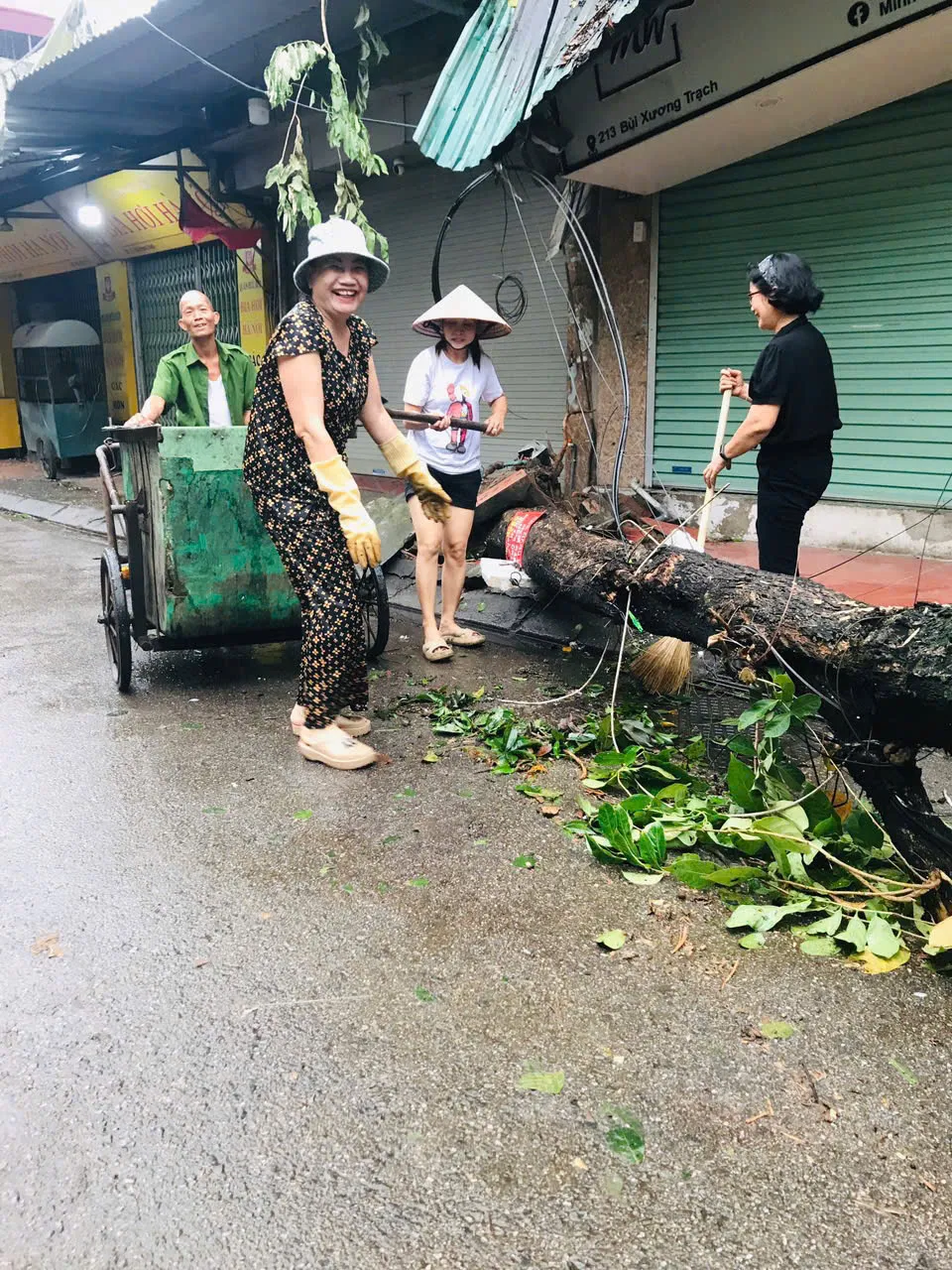 Người dân Hà Nội dọn dẹp đường phố sau cơn bão - Ảnh 6.