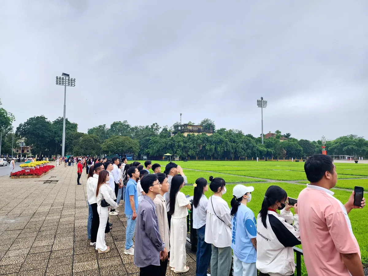 Người dân tham gia lễ chào cờ nhân dịp kỷ niệm 135 năm ngày sinh Chủ tịch Hồ Chí Minh  - Ảnh 4.