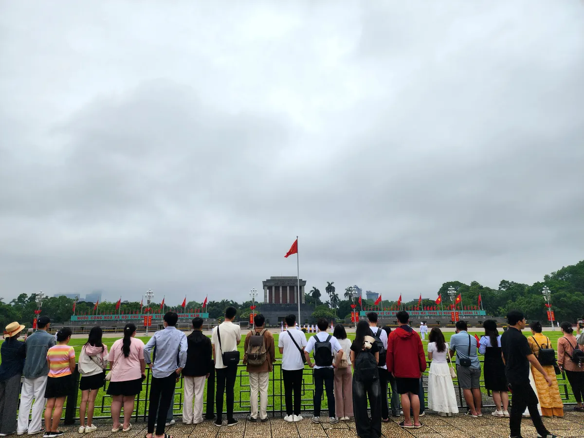 Người dân tham gia lễ chào cờ nhân dịp kỷ niệm 135 năm ngày sinh Chủ tịch Hồ Chí Minh  - Ảnh 1.