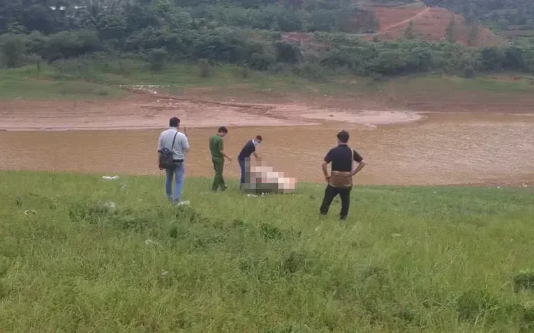 Lực lượng công an khám nghiệm thi thể người đàn ông được phát hiện dưới sông. (Ảnh: PLO)