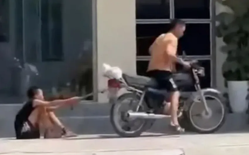 Cháu bé bị trói tay, xích chân kéo lê trên đường bằng xe máy